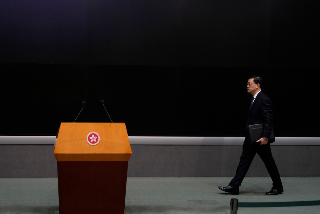 Hong Kong Chief Executive John Lee walks to a press conference with a darken screen in the aftermath of a deadly fire in Hong Kong on Tuesday, Dec. 2, 2025. (AP Photo/Ng Han Guan)