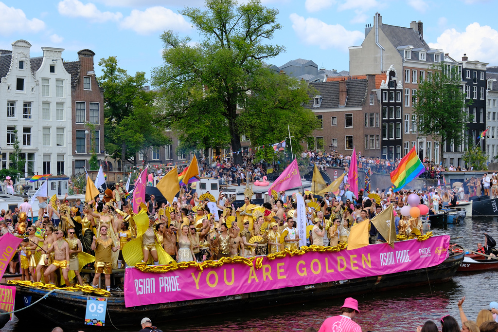 People celebrate atop a boat on one of the Dutch capital's historic canals, Saturday, Aug. 1, 2026, during the Canal Parade, the most popular event of the Pride Amsterdam festival. (AP Photo/Patrick Post)