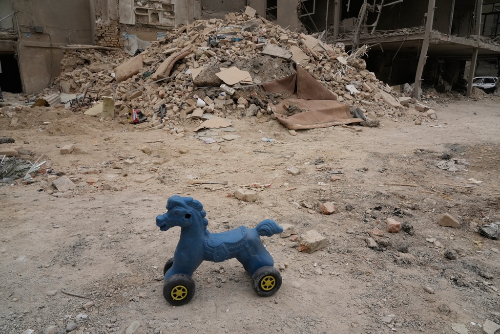 A toy remains on the ground next to a residential building damaged when a nearby police station was hit Friday in a U.S.-Israeli strike in Tehran, Iran, Sunday, March 15, 2026. (AP Photo/Vahid Salemi)