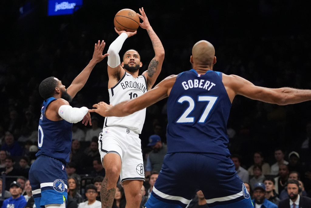 Brooklyn Nets' Tyrese Martin, center, shoots over Minnesota Timberwolves' Mike Conley, left, and Rudy Gobert during the first half of an NBA basketball game Monday, Nov. 3, 2025, at Barclays Center in New York. (AP Photo/Frank Franklin II)