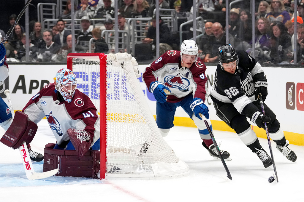 Los Angeles Kings left wing Andrei Kuzmenko, right, takes the puck as Colorado Avalanche defenseman Cale Makar, center reaches in while goaltender Scott Wedgewood watches during the second period of Game 3 in the first round of the NHL hockey Stanley Cup playoffs Thursday, April 23, 2026, in Los Angeles. (AP Photo/Mark J. Terrill)