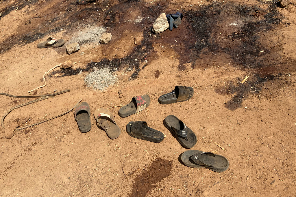 Flip flop shoes and blood stains cover the street days after an attack in the village of Woro, Nigeria, Thursday, Feb. 5, 2026. (AP Photo/Musa Salim)
