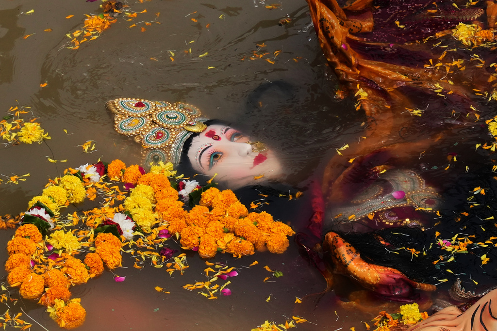 Devotees immerse an idol of Hindu goddess Durga in a makeshift water pit at the end of Durga Puja festival in New Delhi, India, Thursday, Oct. 2, 2025. (AP Photo/Manish Swarup)