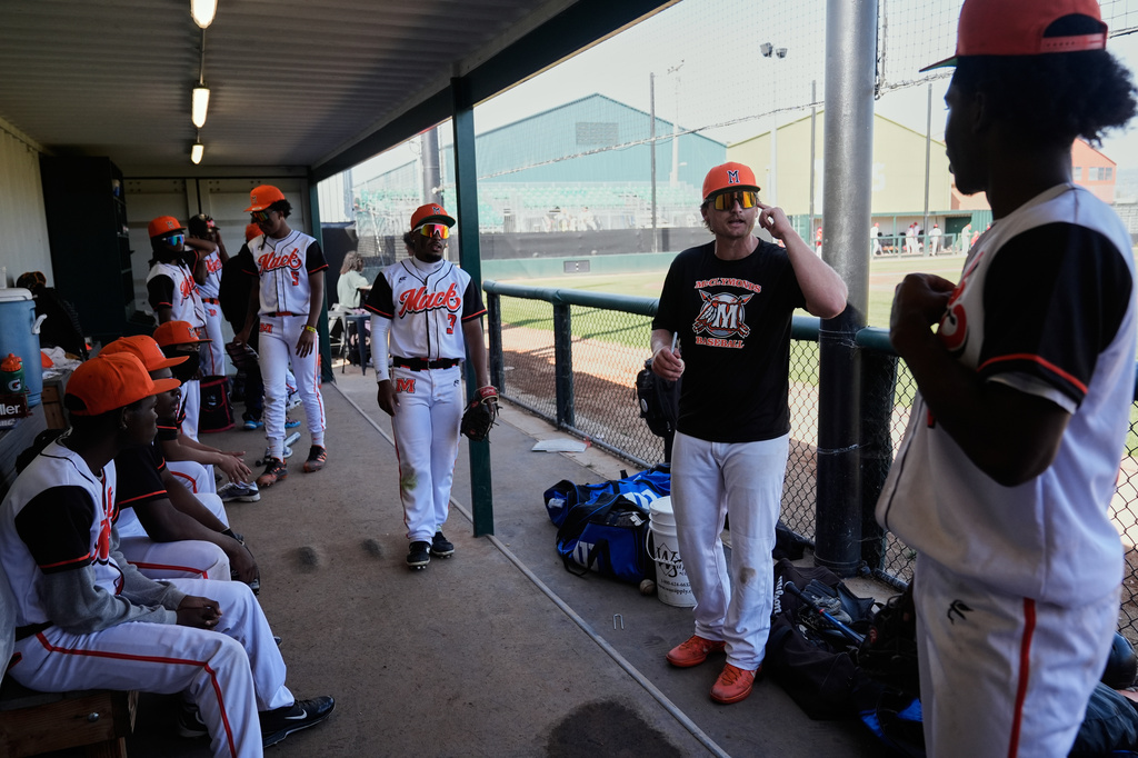 McClymonds High School head coach Jamey Smart, center, talks with his team inside the dugout during the third inning of a baseball game against Skyline High School in Oakland, Calif., Friday, May 1, 2026. (AP Photo/Godofredo A. Vásquez)