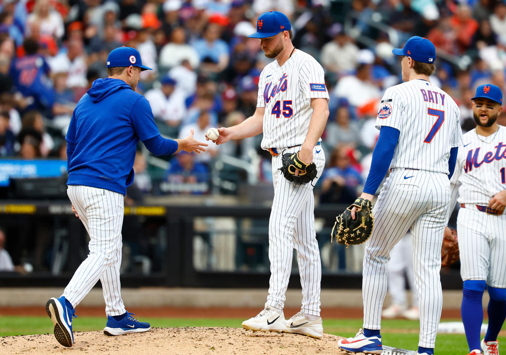 New York Mets interim manager Andy Green, left, takes the ball from pitcher Christian Scott during the fifth inning of a baseball game against the Philadelphia Phillies, Saturday, Sept. 19, 2026, in New York. (AP Photo/Noah K. Murray)