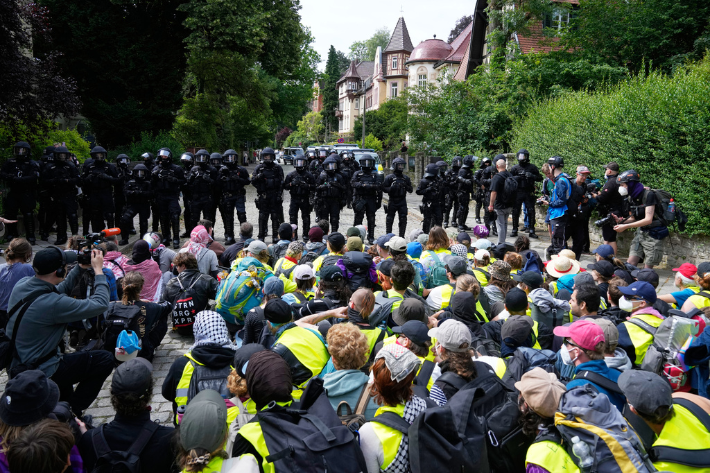 Police officers guard as protesters block a road during a rally against party convention of Alternative for Germany, or AfD in Erfurt, Germany, Saturday, July 4, 2026. (AP Photo/Ebrahim Noroozi)
