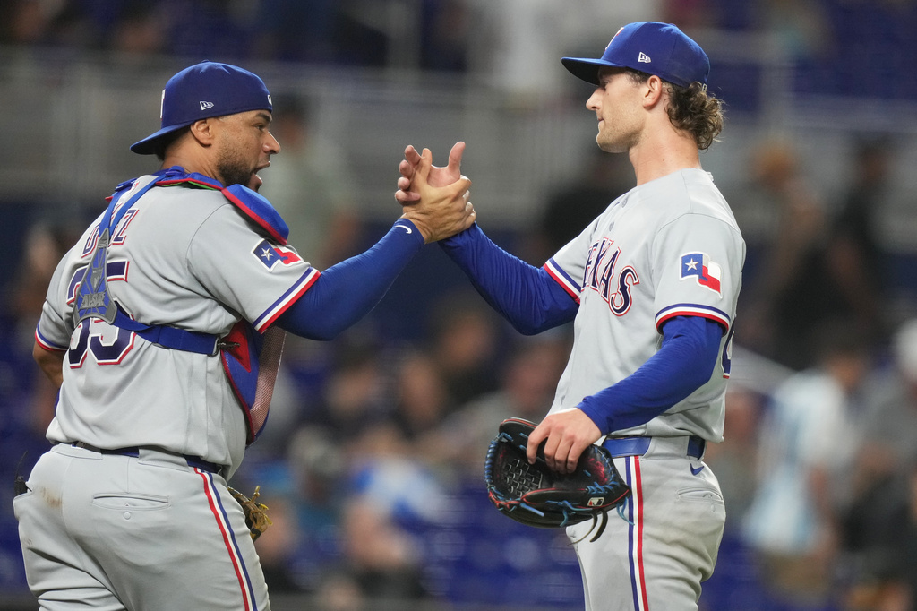 Texas Rangers catcher Elias Díaz (35) shakes hands with pitcher Jacob Latz, right, after the Rangers defeated the Miami Marlins in a baseball game, Monday, June 22, 2026, in Miami. (AP Photo/Lynne Sladky)