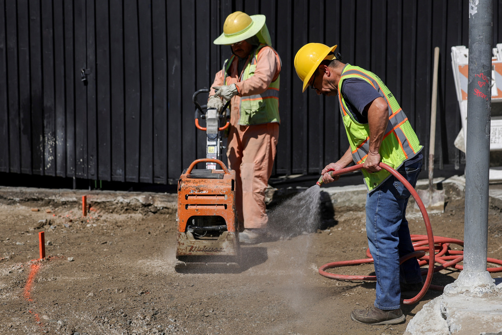 Construction workers spray water during an unseasonably hot day at MacArthur Park on Thursday, Mar. 12, 2026 in Los Angeles. (AP Photo/Ryan Sun)