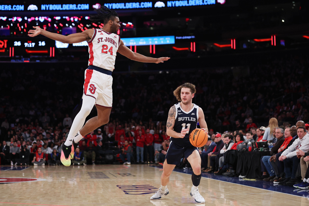 Butler guard Finley Bizjack (11) gets St. John's forward Zuby Ejiofor (24) up in the air before drawing a foul during the first half of an NCAA college basketball game, Wednesday, Jan. 28, 2026, in New York. (AP Photo/Heather Khalifa)