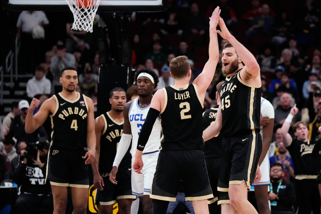 Purdue center Oscar Cluff, right, celebrates with guard Fletcher Loyer after scoring a basket during the second half of an NCAA college basketball game against UCLA in the semifinals of the Big 10 Conference tournament, Saturday, March 14, 2026, in Chicago. (AP Photo/Nam Y. Huh)