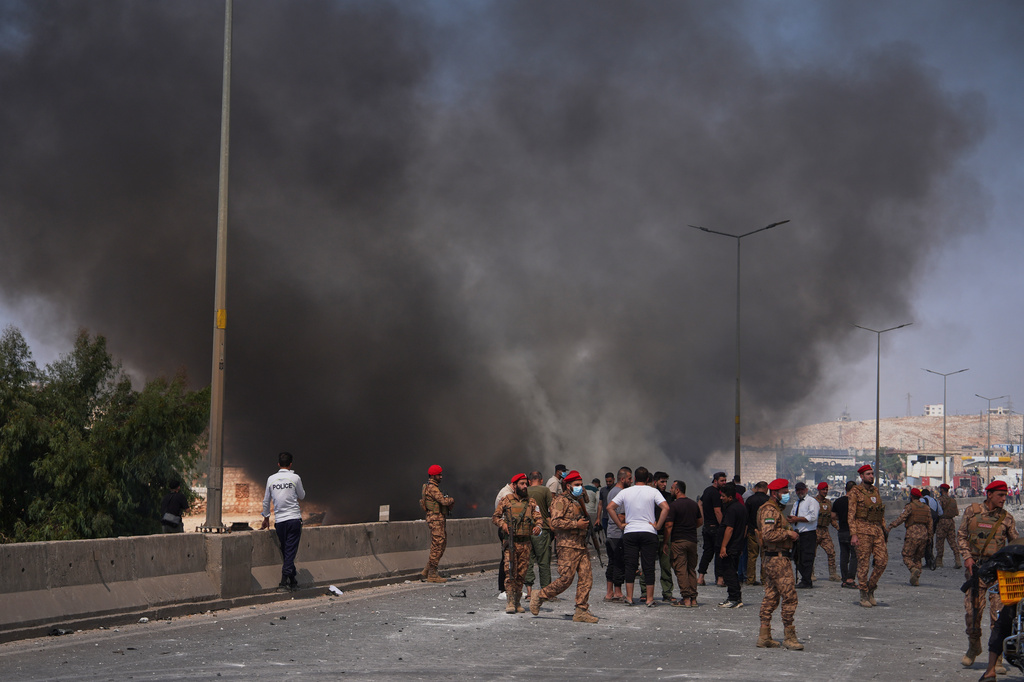 Syrian security forces and others gather as smoke rises after an explosion at what state media said was a weapons depot in the Burj al-Nimra area near Sarmada, in Idlib province, Syria, Wednesday, Sept. 9, 2026.(AP Photo/Omar Albam)