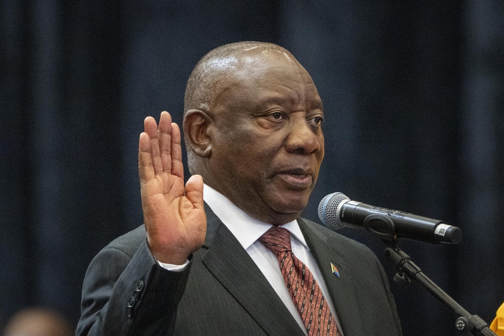 FILE - South African President Cyril Ramaphosa raises his hand as he is sworn is as a member of Parliament ahead of an expected vote by lawmakers to decide if he is reelected as leader of the country in Cape Town, South Africa, June 14, 2024. (AP Photo/Jerome Delay, file)
