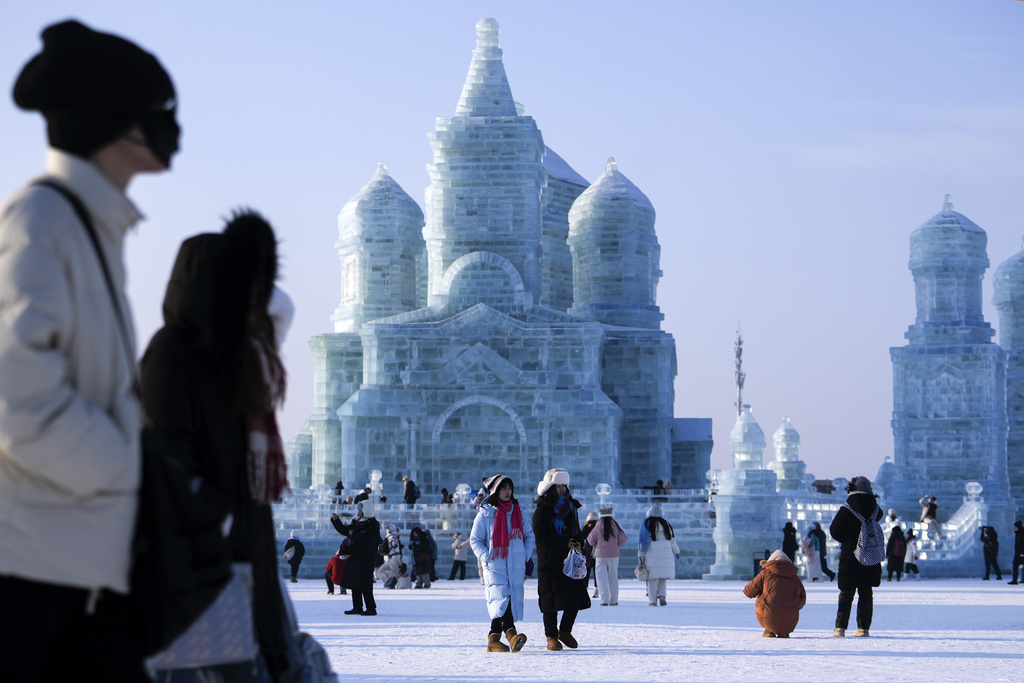 Visitors tour by the ice structures during the Harbin Ice and Snow World in Harbin, China's Heilongjiang province on Monday, Jan. 6, 2025. (AP Photo/Andy Wong)