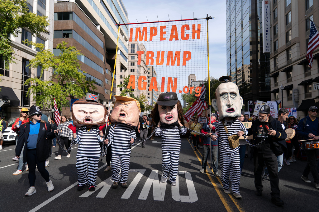 Demonstrators wear costumes and carry signs as they march to the national Mall during a No Kings protest in Washington, Saturday, Oct. 18, 2025. (AP Photo/Jose Luis Magana)