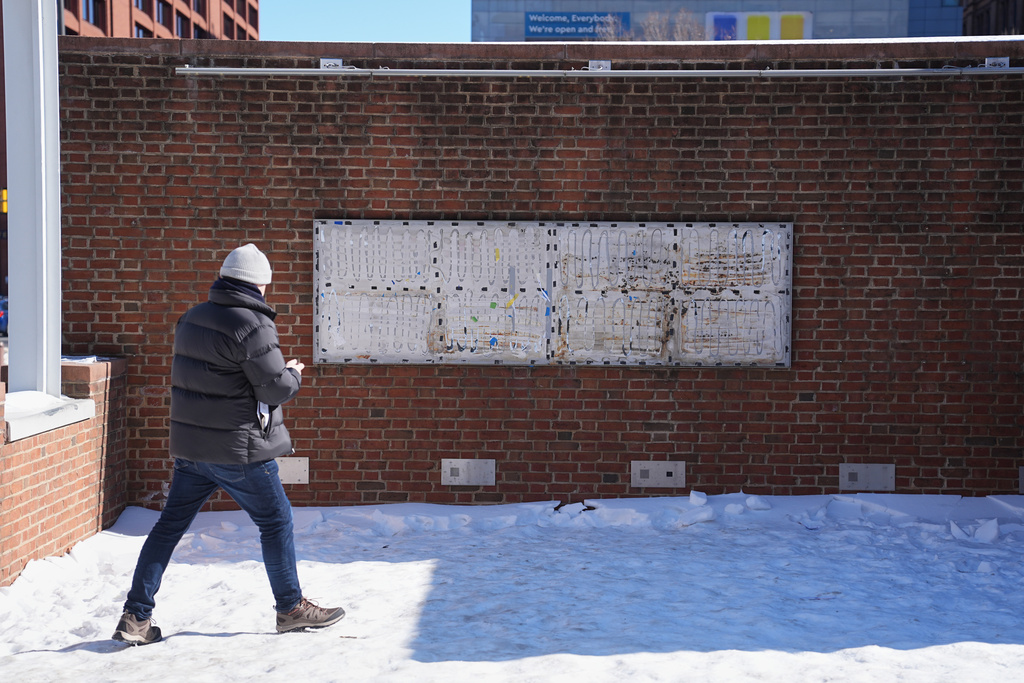 A person moves to photograph the location of the now removed explanatory panels that were part of an exhibit on slavery at President's House Site in Philadelphia, Friday, Jan. 30, 2026. (AP Photo/Matt Rourke)