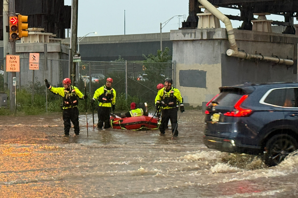 In this photo provided by the City of Jersey City, first responders try to rescue stranded people in Jersey City, N.J., Thursday, Aug. 20, 2026, after storms went through the area. (City of Jersey City via AP)null