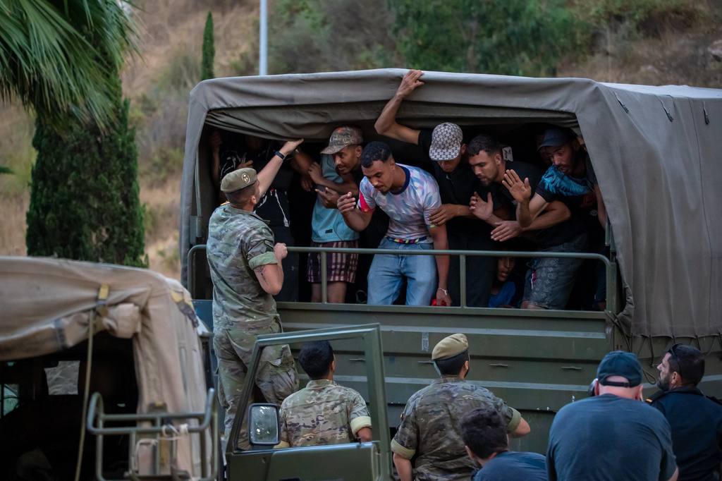 Migrants who crossed into Spain are escorted by Spanish soldiers towards the Spanish-Moroccan border for their return to Morocco from the Spanish enclave of Ceuta, Sunday, Aug. 2, 2026. (AP Photo/Antonio Sempere)