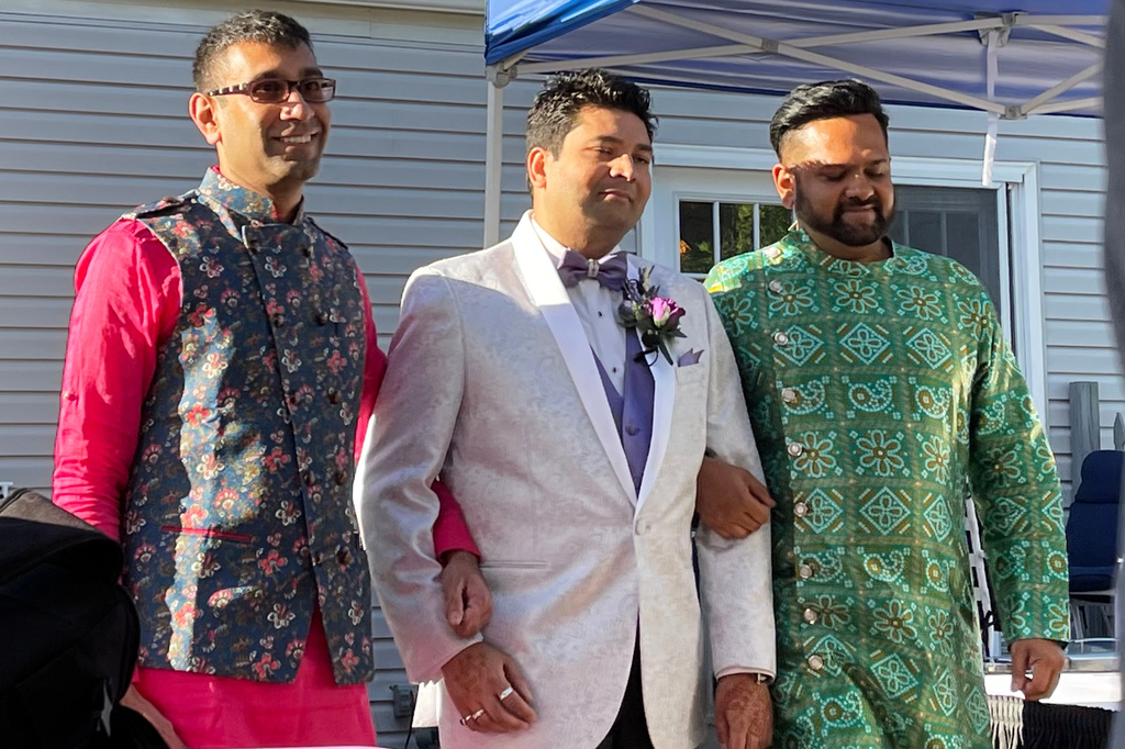 This photo provided by Jolene Gosha shows Venus Patel, left, walking his friend, Pratik Jhaveri, center, down the wedding aisle in Collinsville, Ill., June 18, 2022. CORRECTION: Corrects Jolene's surname from Gosh to Gosha. (Jolene Gosha via AP)