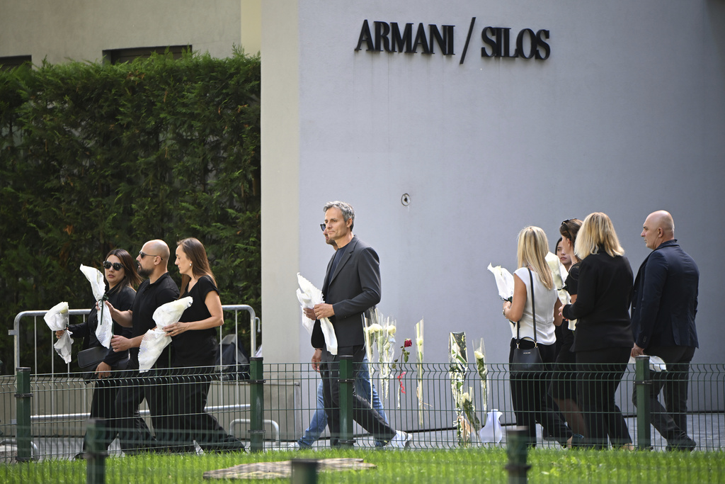 Employees arrive at the Armani/Teatro in Milan, northern Italy, to pay their respects to designer Giorgio Armani, who died Thursday at age 91, Saturday, Sept. 6, 2025. (AP Photo/Nicola Marfisi)