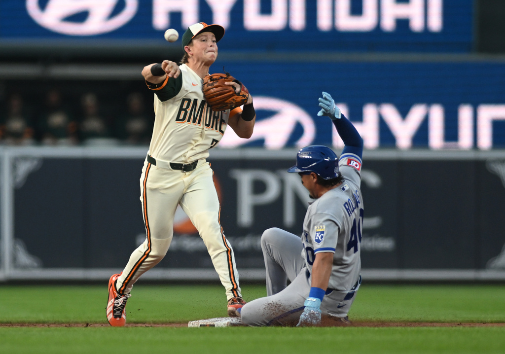 Baltimore Orioles second baseman Jackson Holliday, left, puts out Kansas City Royals' Josh Rojas, right, while turning a double play on a ground ball hit by Royals' Nick Loftin during the second inning of a baseball game Friday, July 10, 2026, in Baltimore. (AP Photo/Steve Ruark)