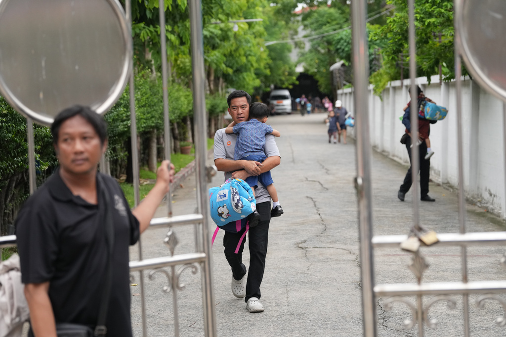 A parent leaves after picking his child after a shooting at the Debsirin Nonthaburi School in Thailand's Nonthaburi province, Friday, Aug. 7, 2026. (AP Photo/Sakchai Lalit)