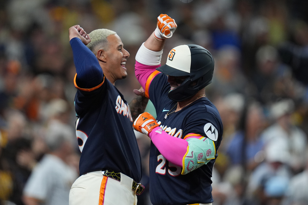 San Diego Padres' Ty France, right, celebrates with teammate Manny Machado after hitting a three-run home run during the fifth inning of a baseball game against the Miami Marlins Friday, Sept. 18, 2026, in San Diego. (AP Photo/Gregory Bull)