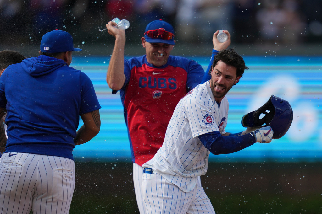 Chicago Cubs' Dansby Swanson, right, celebrates with teammates after driving in the game-winning run in the 10th inning of a baseball game against the Philadelphia Phillies, Thursday, April 23, 2026, in Chicago. (AP Photo/Erin Hooley)