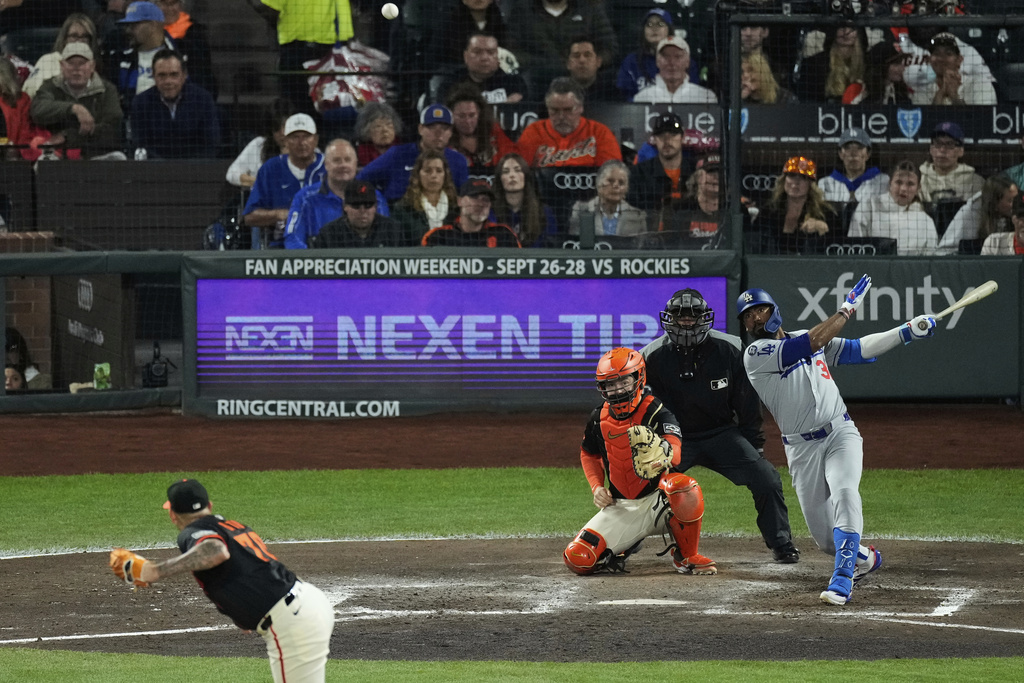 Los Angeles Dodgers' Teoscar Hernández, right, hits a two-run double during the fifth inning of a baseball game against the San Francisco Giants, Saturday, Sept. 13, 2025, in San Francisco. (AP Photo/Godofredo A. Vásquez)