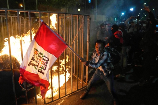 FILE - A demonstrator waves a Peruvian flag as a cardboard doll burns in front of Congress during a protest against new President Jose Jeri in Lima, Peru, Wednesday, Oct. 15, 2025. (AP Photo/Martin Mejia, File) FILE - A demonstrator waves a Peruvian flag as a cardboard doll burns in front of Congress during a protest against new President Jose Jeri in Lima, Peru, Wednesday, Oct. 15, 2025. (AP Photo/Martin Mejia, File)