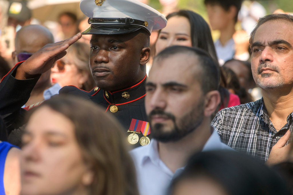 U.S. Marine Sgt. Diakaria Sangare, center, from Guinea, salutes the playing of the national anthem at a naturalization ceremony on Independence Day at George Washington's Mount Vernon, Saturday, July 4, 2026, in Alexandria, Va. (AP Photo/Rod Lamkey, Jr.)