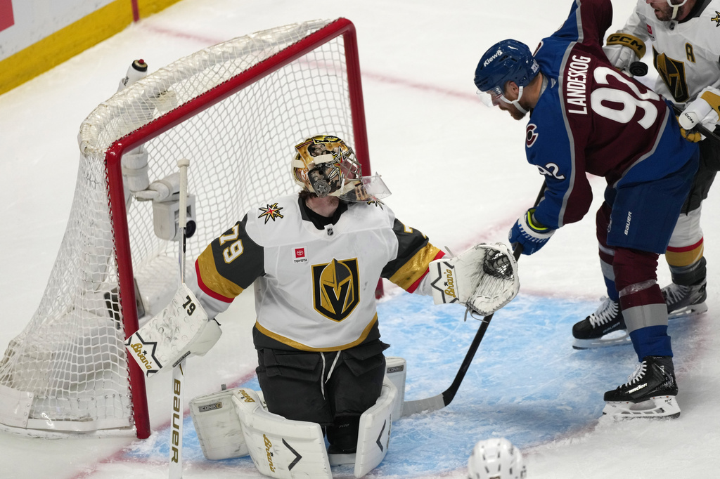Colorado Avalanche left wing Gabriel Landeskog, right, tries to redirect the puck as Vegas Golden Knights goaltender Carter Hart defends during the first period in Game 1 of the Western Conference finals NHL hockey Stanley Cup playoff series Wednesday, May 20, 2026, in Denver. (AP Photo/David Zalubowski)