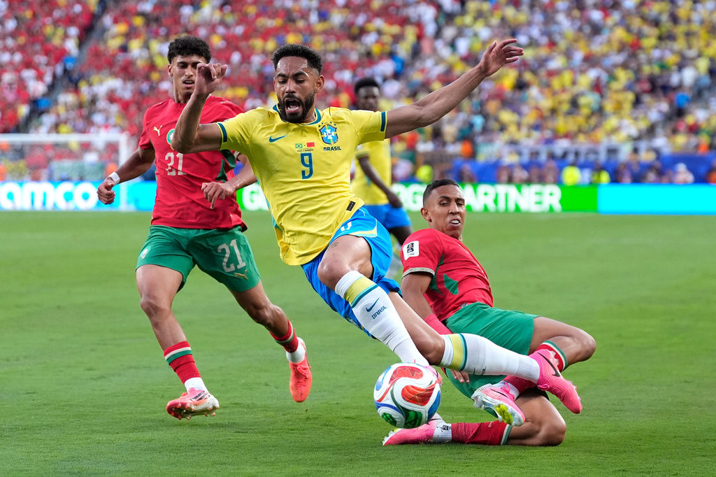 Brazil's Matheus Cunha (9) challenges for the ball with Morocco's Soufiane Rahimi (9) during the World Cup Group C soccer match between Brazil and Morocco in East Rutherford, N.J., near New York, Saturday, June 13, 2026. (AP Photo/Yuki Iwamura)
