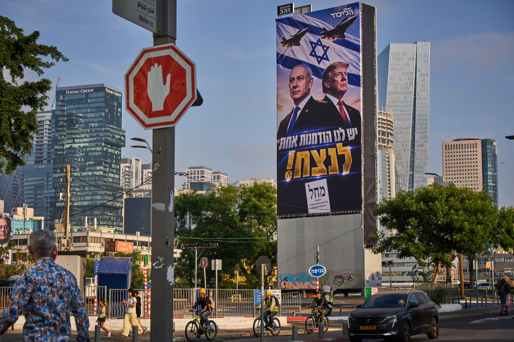 People walk past a Likud Party campaign billboard featuring U.S. President Donald Trump and Israeli Prime Minister Benjamin Netanyahu, with a Hebrew message reading, "We have one opportunity to win," in Tel Aviv, Israel, Monday, Oct. 26, 2026. (AP Photo/Oded Balilty)