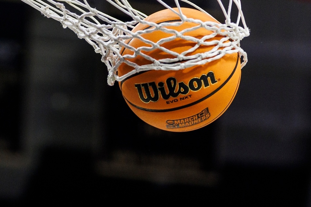 FILE - A basketball with a March Madness logo is seen going through a net prior to a second round of the NCAA college basketball tournament between Notre Dame and Michigan, March 23, 2025, in South Bend, Ind. (AP Photo/John Mersits, File)