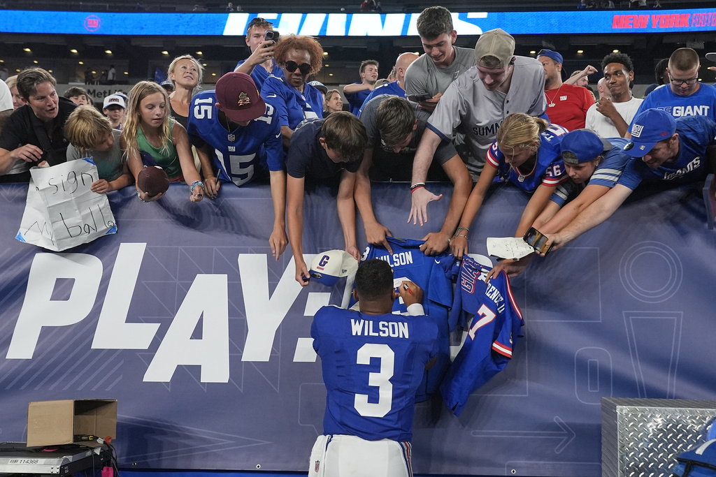 New York Giants quarterback Russell Wilson (3) signs autographs after playing against the New York Jets in a preseason NFL football game, Saturday, Aug. 16, 2025, in East Rutherford, N.J. (AP Photo/Pamela Smith)