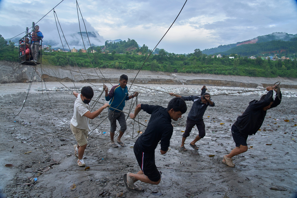 FILE - Residents commute across the Trishuli River on a newly installed zipline in the aftermath of flash floods at Bidur, Nuwakot district, Nepal, Sept. 5, 2026. (AP Photo/Niranjan Shrestha, File)