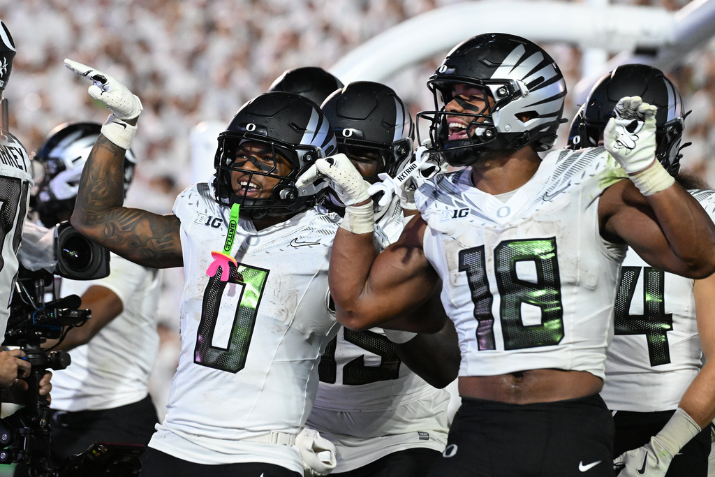 Oregon running back Jordon Davison (0) celebrates a touchdown with tight end Kenyon Sadiq (18) against Penn State during the fourth quarter of their NCAA college football game, Saturday, Sept. 27, 2025, in State College, Pa. (AP Photo/Barry Reeger)