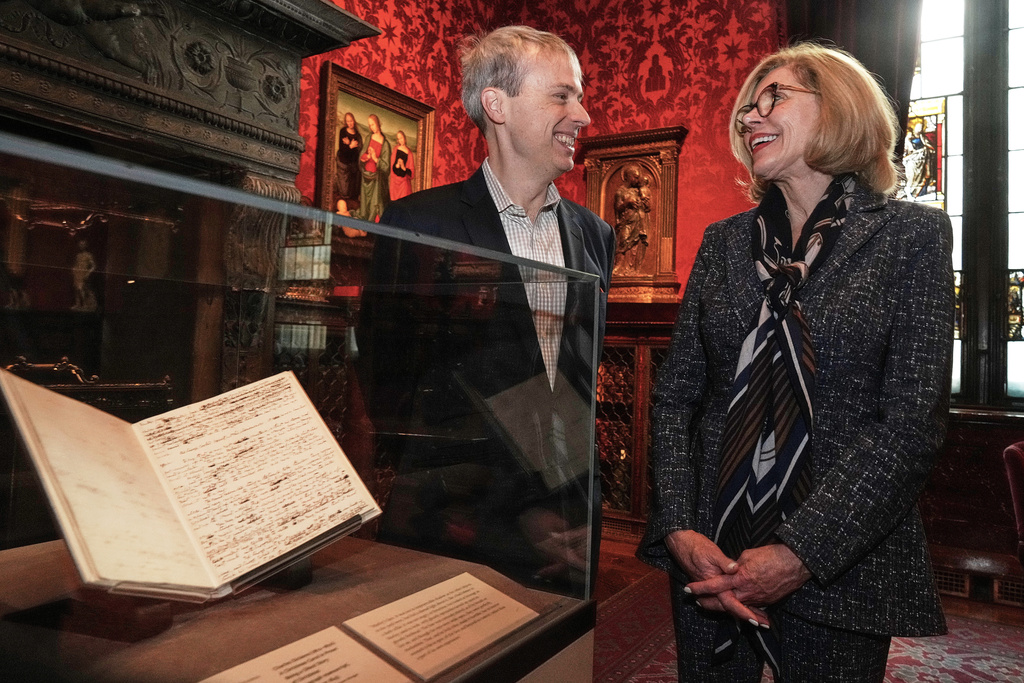 Skylark Artistic Director Matthew Guard and Christine Baranski are interviewed beside "A Christmas Carol In Prose; Being a Ghost Story of Christmas" by Charles Dickens, Dec. 1843," at The Morgan Library & Museum, in New York, Monday, Dec. 1, 2025. (AP Photo/Richard Drew)