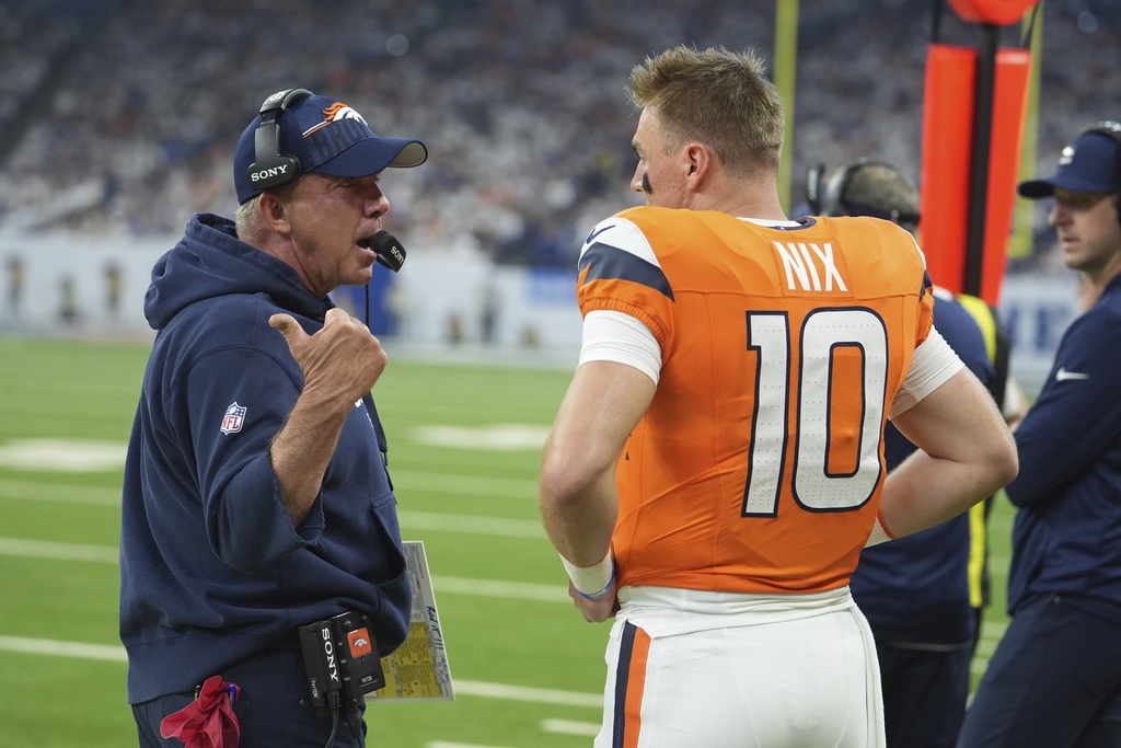 Denver Broncos head coach Sean Payton talks with quarterback Bo Nix during the first half an NFL football game against the Indianapolis Colts, Sunday, Sept. 14, 2025, in Indianapolis. (AP Photo/Michael Conroy)