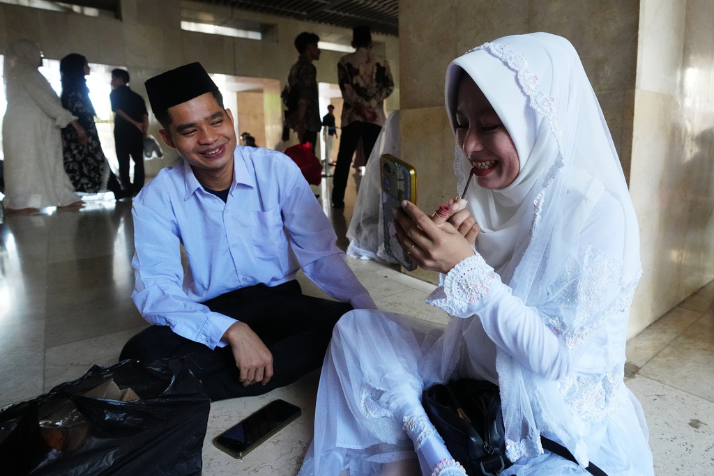 A couple prepare for a mass wedding ceremony at Istiqlal Mosque in Jakarta, Indonesia, Wednesday, Dec. 3, 2025. (AP Photo/Tatan Syuflana)