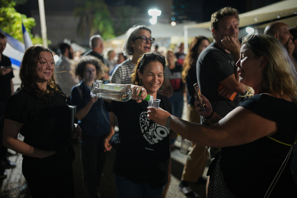 Relatives and supporters of Israeli hostages held by Hamas in the Gaza Strip celebrate after the announcement that Israel and Hamas have agreed to the first phase of a peace plan, as they gather at a plaza known as the hostages square in Tel Aviv, Israel, Thursday, Oct. 9, 2025. (AP Photo/Emilio Morenatti)