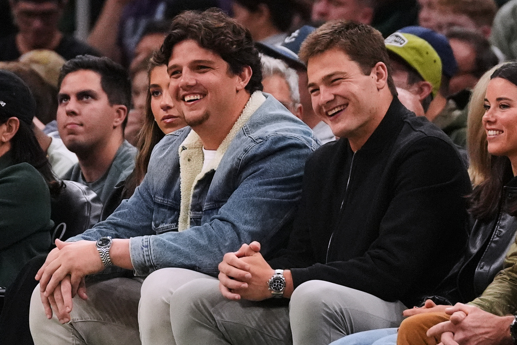 New England Patriots quarterback Drake Maye, right, sits with teammate Will Campbell during first half of an NBA basketball game between the Boston Celtics and Utah Jazz, Monday, Nov. 3, 2025, in Boston. (AP Photo/Charles Krupa)