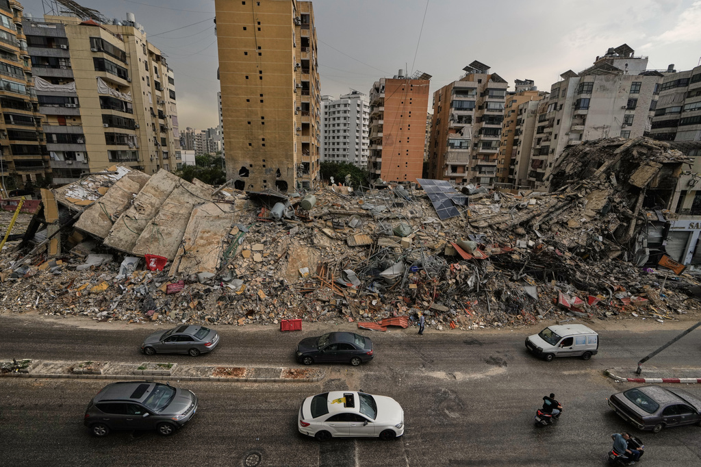 Residents drive past the rubble of destroyed buildings in Dahiyeh, Beirut's southern suburbs, Lebanon, Friday, April 17, 2026, following a ceasefire between Israel and Hezbollah. (AP Photo/Bilal Hussein)