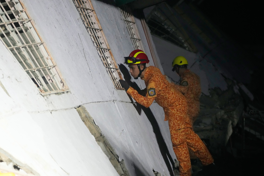 Rescuers check for survivors from the ruins of a collapsed building, Wednesday, Oct. 1, 2025 after a strong earthquake struck Bogo city, Cebu Province, Central Philippines. (AP Photo/Aaron Favila)