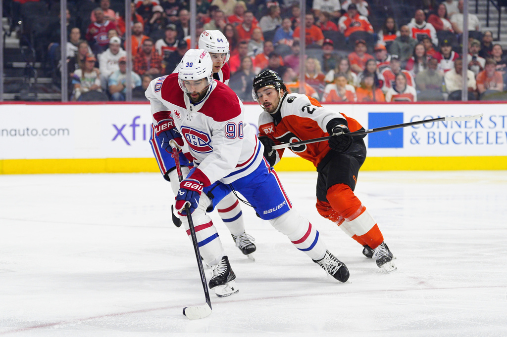 Montréal Canadiens' Joe Veleno skates with the puck past Philadelphia Flyers' Noah Cates (27) during the second period of an NHL hockey game, Tuesday, April 14, 2026, in Philadelphia. (AP Photo/Derik Hamilton)