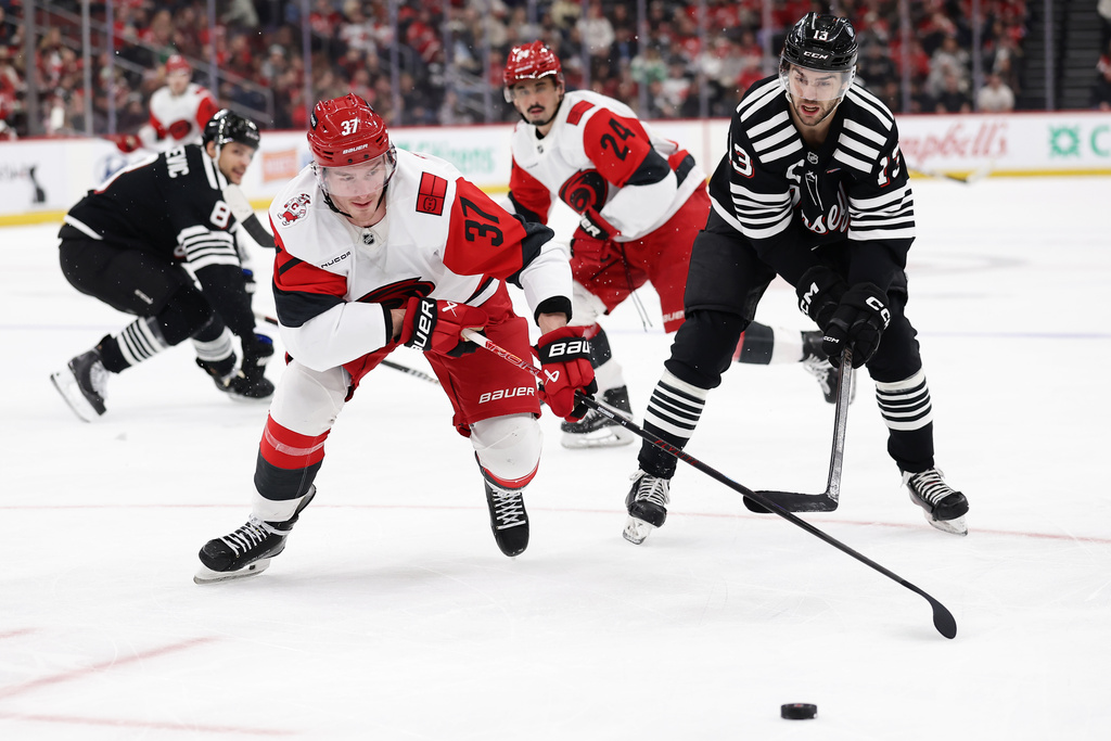 Carolina Hurricanes right wing Andrei Svechnikov (37) battles for the puckw ith New Jersey Devils center Nico Hischier (13) during the first period of an NHL hockey game Saturday, Jan. 17, 2026, in Newark, N.J. (AP Photo/Adam Hunger)