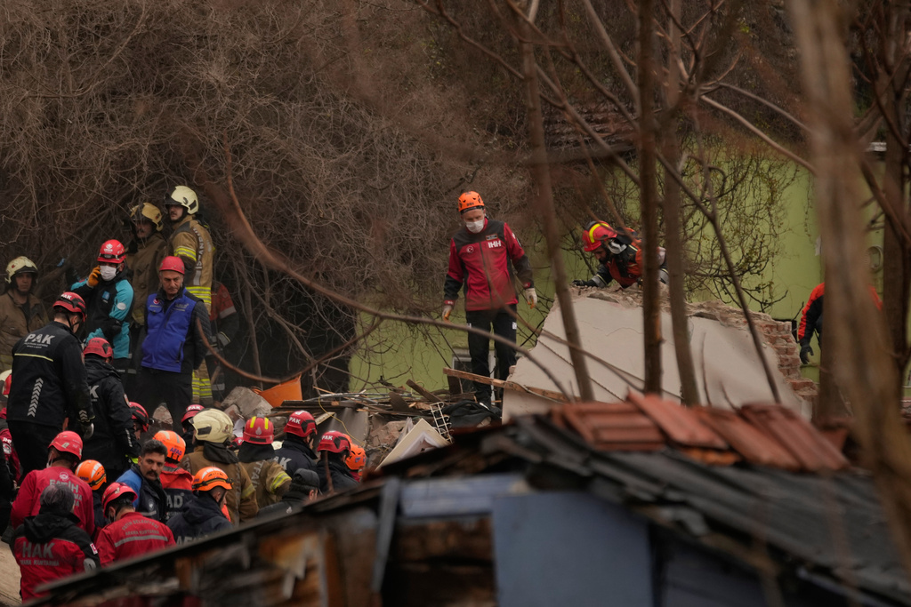 Rescue teams and firefighters search the site where two residential buildings collapsed in Istanbul, Sunday, March 22, 2026. (AP Photo/Khalil Hamra)