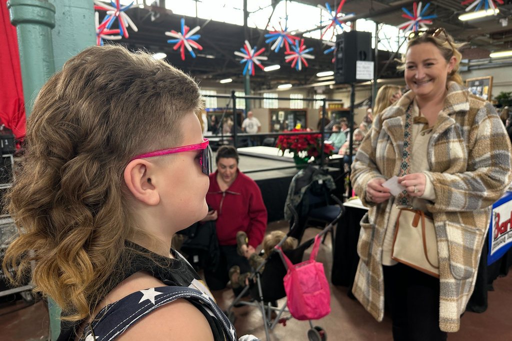 Meredith Nelson, right, smiles at her son, Mikey "The Mullet" Nelson, an 8-year old-contestant in a mullet hairstyle contest, Monday, Jan. 12, 2026 in Harrisburg, Pa. (AP Photo/Tassanee Vejpongsa)