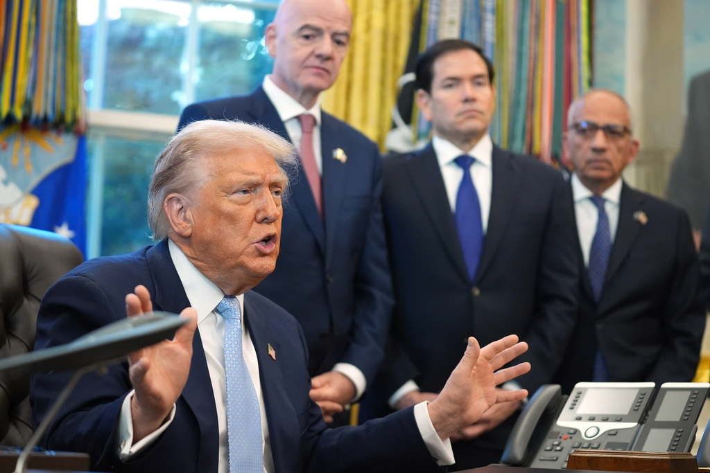 President Donald Trump answers questions from reporters during a meeting with the White House task force on the 2026 FIFA World Cup in the Oval Office of the White House, Monday, Nov. 17, 2025, in Washington, as FIFA President Gianni Infantino, Secretary of State Marco Rubio and FIFA senior adviser Carlos Cordeiro listen. (AP Photo/Evan Vucci)