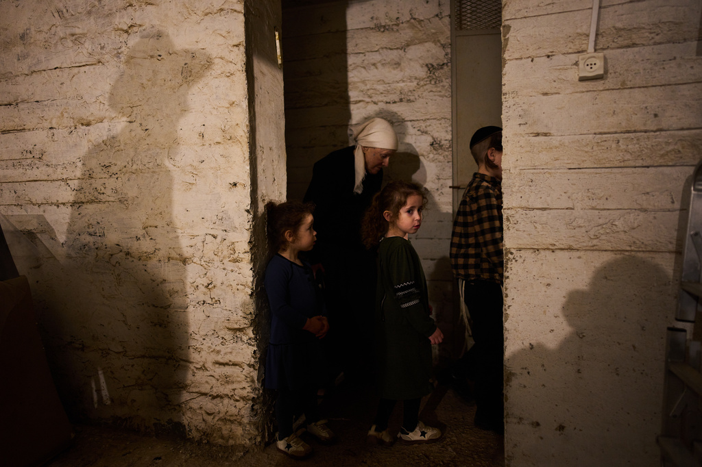 People take cover in a bomb shelter as air raid sirens warn of incoming Iranian missile strikes in Bnei Brak, Israel, Wednesday, April 1, 2026. (AP Photo/Oded Balilty)